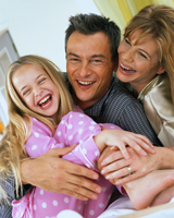 Happy Family Laughing in Bed